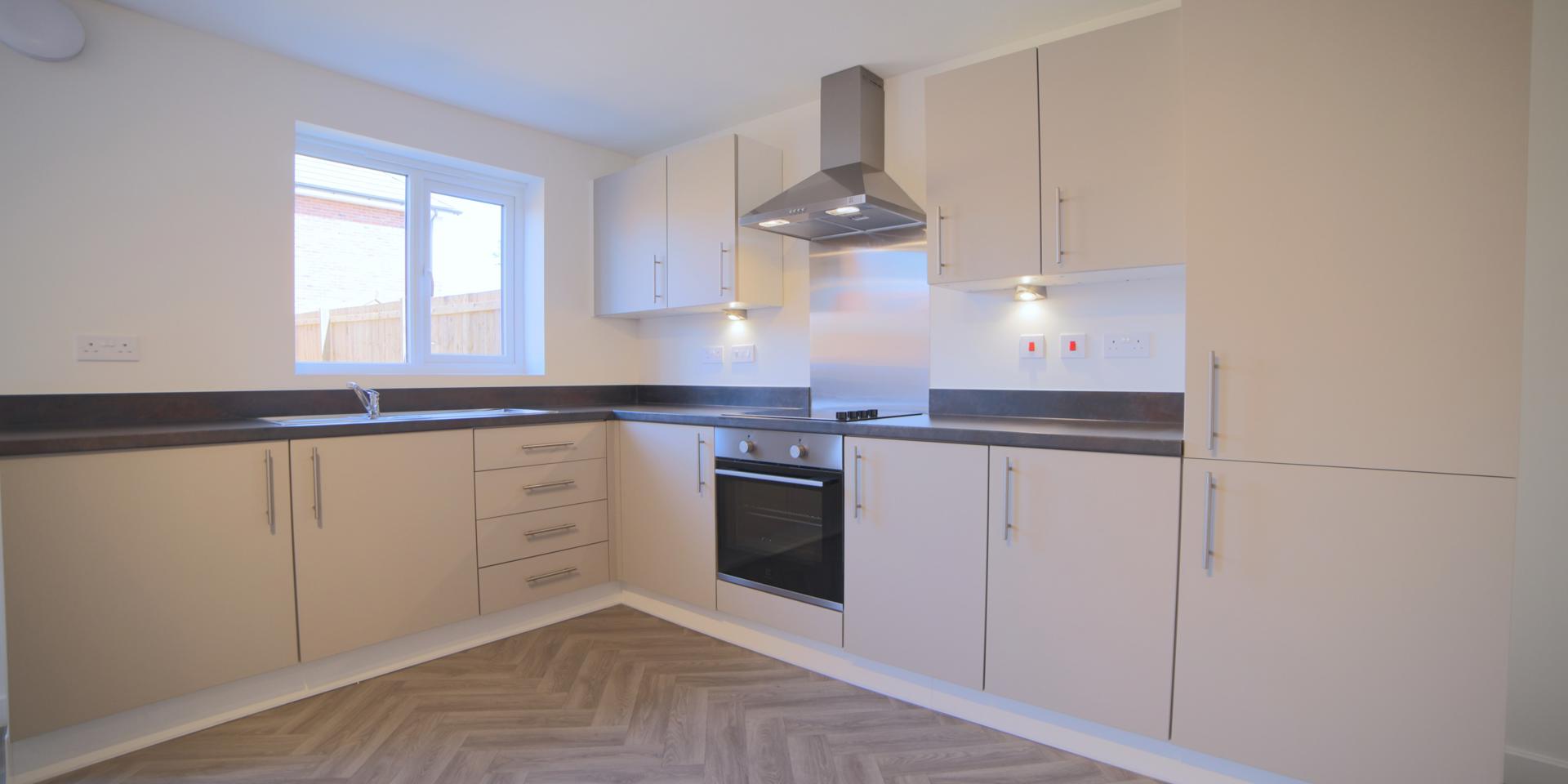 The fitted kitchen has floor and wall cupboards plus integrated electric oven and hob