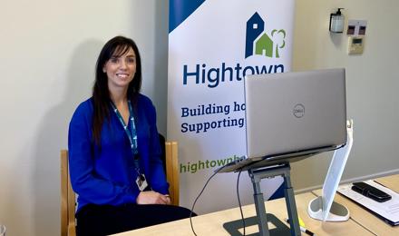 Woman smiling sitting behind a laptop