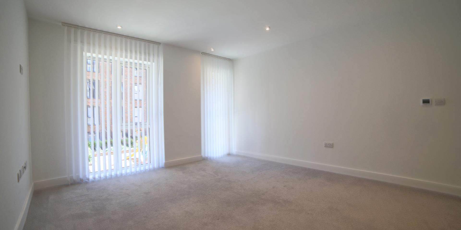 There are vertical blinds in the living area to the large windows